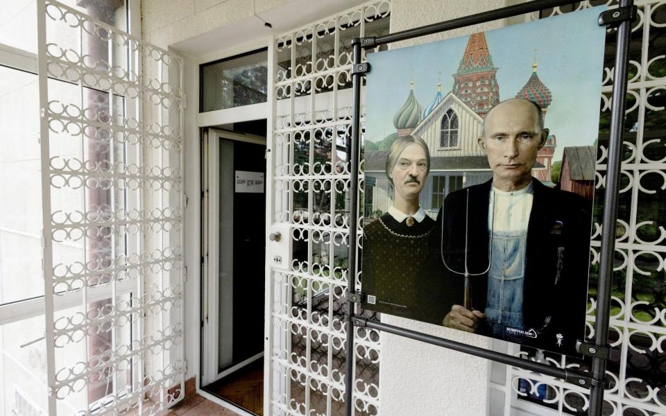 A picture depicting Russian President Vladimir Putin and Belarusian leader Alexander Lukashenko as farmers, reminiscent of Grant Wood's 'American Gothic' painting, is placed in front of the entrance to the 'Belarusian House', an institution supporting democratic activity in Belarus, in Warsaw, Poland, July 25, 2023.