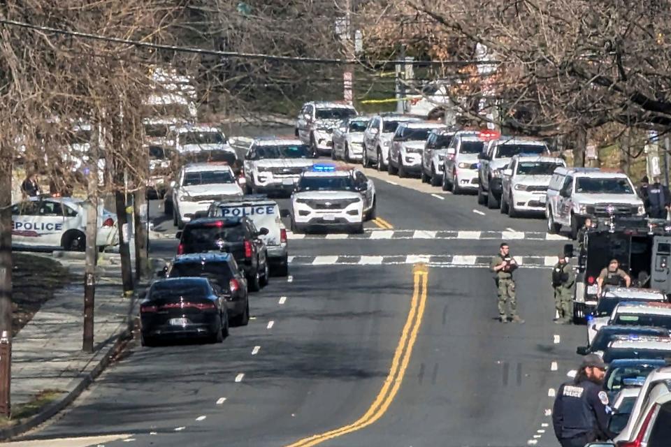 Washington Metropolitan Police are shown near a scene where three police officers were shot and a fourth suffered minor injuries while responding to a shooting, Wednesday morning, Feb. 14, 2024 in Washington.