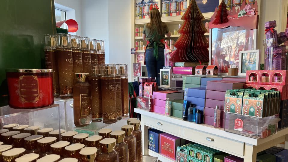 A woman stocks shelves with Christmas gifts at Bath & Body Works in Annapolis, Maryland, on December 14. - Jim Watson/AFP/Getty Images