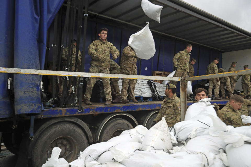 Soldiers from The Highlanders, 4th Battalion, the Royal Regiment of Scotland assist with flood defences as the UK prepares for widespread weather disruption as Storm Dennis approaches, in Mytholmroyd, West Yorkshire, England, Saturday, Feb.15, 2020. Enormous waves churned across the North Atlantic on Saturday as Britain braces for a second straight weekend of wild winter weather and flooding that's already seen the army deployed to help out residents in northern England. (Danny Lawson/PA via AP)