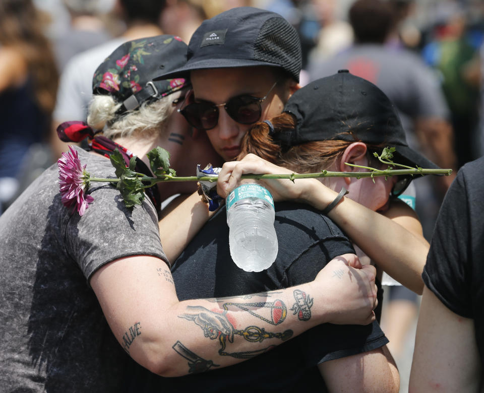 Mourners embrace each other as they remember Heather Heyer who was killed during last year's Unite the Right rally in Charlottesville, Va., Sunday, Aug. 12, 2018. On that day, white supremacists and counterprotesters clashed in the city streets before a car driven into a crowd struck and killed Heyer. (AP Photo/Steve Helber)