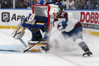 St. Louis Blues goaltender Ville Husso, left, stops a shot from Colorado Avalanche's Logan O'Connor (25) during the first period in Game 4 of an NHL hockey Stanley Cup second-round playoff series Monday, May 23, 2022, in St. Louis. (AP Photo/Jeff Roberson)