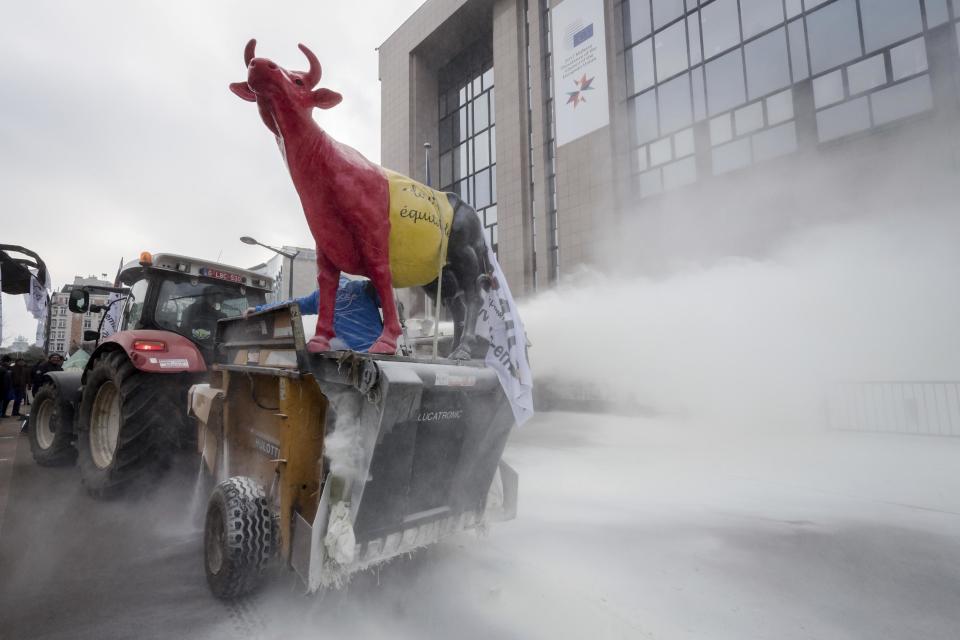 European dairy farmers spray the EU Council building with milk powder to protest the crisis in their sector, in Brussels on Monday, Jan. 23, 2017. The sector has been hit with sagging prices and production costs squeezing profits to the extent that has driven many farmers to the brink of bankruptcy. The EU's executive Commission has approved some support measures over the past year, but the farmers fear that releasing more milk powder on the market would further complicate their plight. (AP Photo/Geert Vanden Wijngaert)