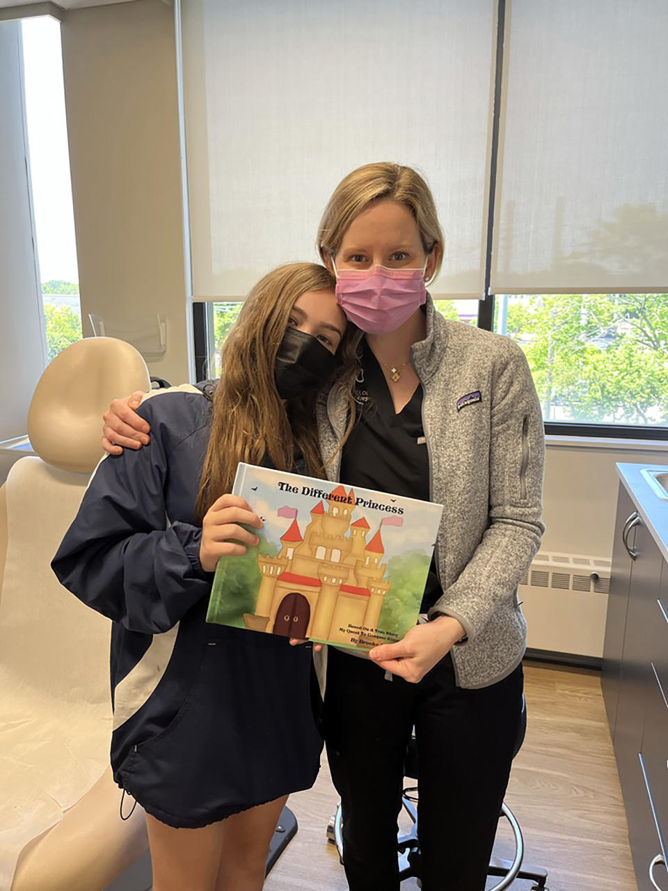 Brittany Craiglow con Brooke y un libro que Brooke escribió sobre su experiencia con la alopecia. (Brittany Craiglow via The New York Times)

