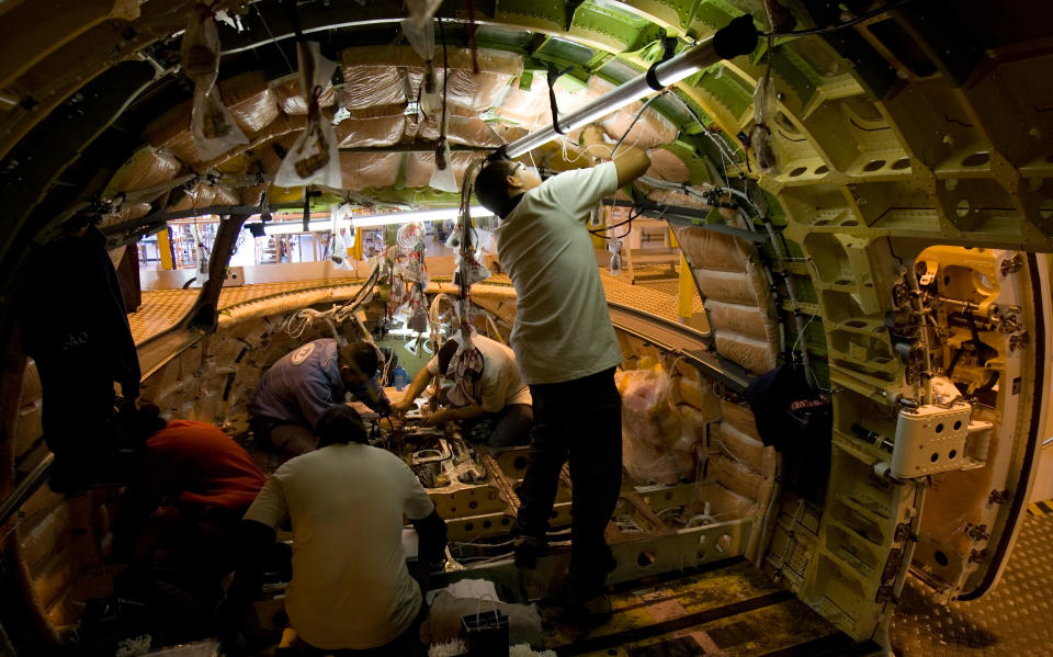 FILE - In this June 27, 2007 file photo, Embraer employees work on an Embraer 190 commercial jet at the company's factory in Sao Jose dos Campos, Brazil. For more than a decade, Brazil has been one of the developing world's great hopes, outpacing the growth of Western Europe and the U.S. Many even predicted it would soon become an economic superpower, but now analysts generally believe the big boom is past. Economic turmoil in Europe is cutting into demand for manufactured goods such as aircraft. (AP Photo/Victor R. Caivano, File)