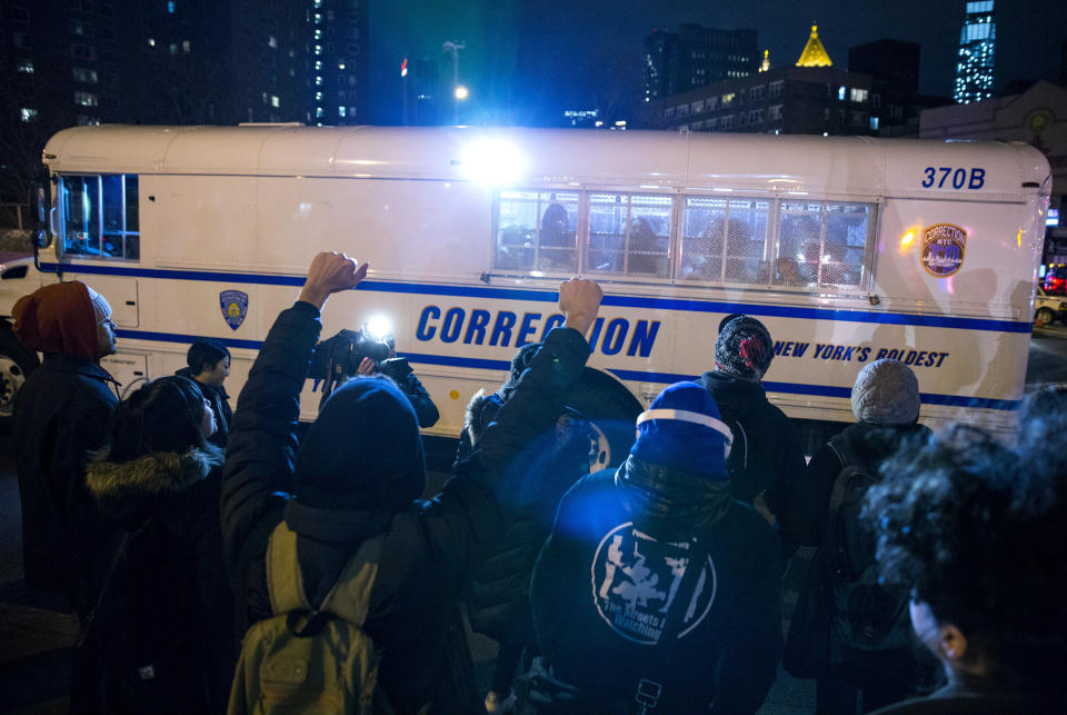 Fellow protesters cheer those in police custody in a correction bus at the Manhattan side of the Manhattan Bridge Thursday, Dec. 4, 2014, in New York, after several protesters were arrested as they tried to block the bridge entrance protesting against a grand jury's decision not to indict the police officer involved in the death of Eric Garner. A grand jury cleared a white New York City police officer Wednesday in the videotaped chokehold death of Garner, an unarmed black man, who had been stopped on suspicion of selling loose, untaxed cigarettes, a lawyer for the victim's family said. (AP Photo/Craig Ruttle)