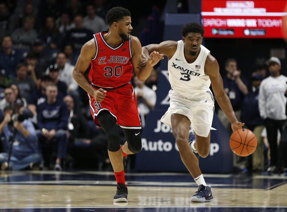 Xavier guard Quentin Goodin (3) is pressured by St. John's guard LJ Figueroa (30) as he drives the ball up court during the first half of an NCAA college basketball game, Sunday, Jan. 5, 2020, in Cincinnati. (AP Photo/Gary Landers)