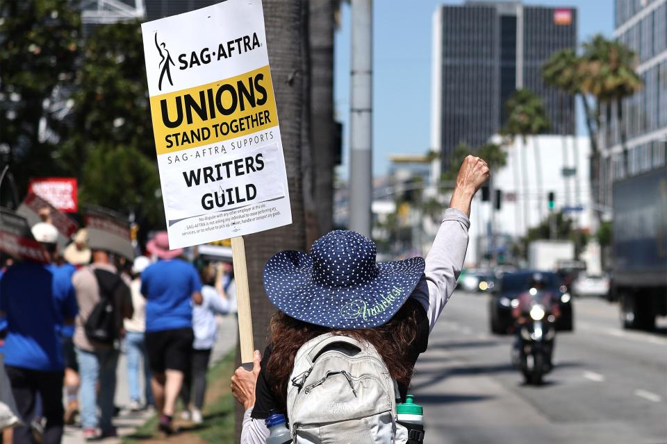 A sign reads 'Unions Stand Together' as SAG-AFTRA members walk the picket line in solidarity with striking WGA (Writers Guild of America) workers outside Netflix offices on July 12, 2023 in Los Angeles, California. Members of SAG-AFTRA, which represents actors and other media professionals, may go on strike by 11:59 p.m. today which could shut down Hollywood productions completely with the writers in the third month of their strike against Hollywood studios.