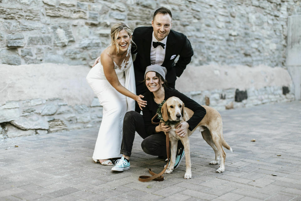 In this Oct. 19, 2018 photo, Lara Leinen of Doggy Social MN LLC poses with Lindsay and Kyle Hofer, and their dog Carter, at their wedding in Minneapolis, Minn. It's no longer unusual for brides and grooms to include pets in their wedding photos or even in the ceremony. But it can be tough to manage that along with everything else. (Russell Heeter Photography/Lara Leinen via AP)