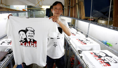 Vietnamese shop owner Truong Thanh Duc shows a t-shirt for sale with images of U.S. President Donald Trump and North Korean leader Kim Jong Un ahead of USA-DPRK Summit in Hanoi, Vietnam February 21, 2019. REUTERS/Kham
