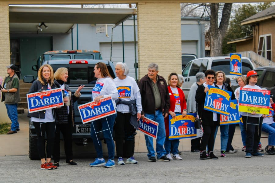 Protesters with Teachers for Darby stand together on Twohig Aveune waiting Gov. Greg Abbott's arrival to Central Firehouse Pizzeria in downtown San Angelo.
