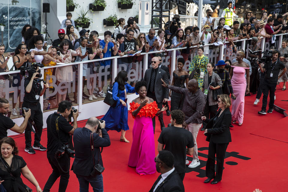 Viola Davis, center, and Lashana Lynch, right in pink dress, walk the red carpet for "The Woman King" in a photo taken from the vantage point of the RBC Red Carpet Gallery, at the Toronto International Film Festival, in Toronto, Friday, Sept. 9, 2022. (Chris Young/The Canadian Press via AP)