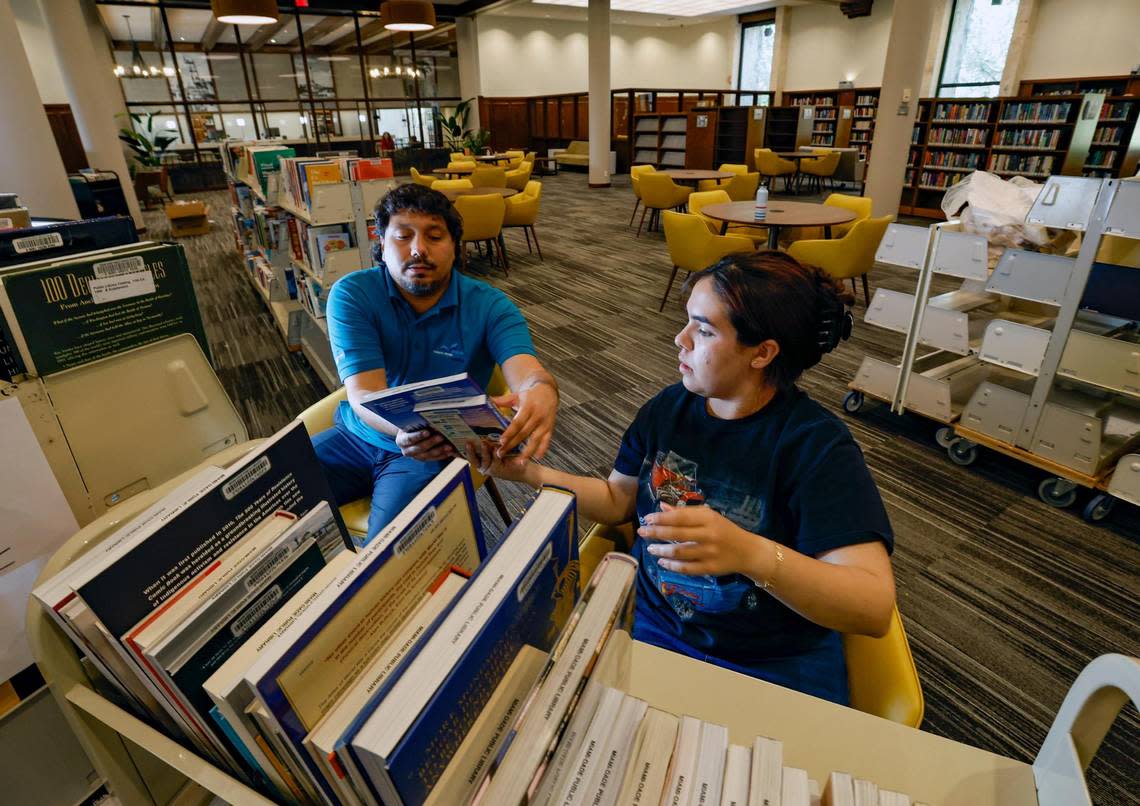 Andres Martinez and Maria Vazquez unpack books at Coral Gables Branch Library as they help prepare to reopen on Monday, May 22 after the library closed for renovations in 2021. The library is located at 3443 Segovia Street in Coral Gables on Tuesday, May 16, 2023. Al Diaz/adiaz@miamiherald.com