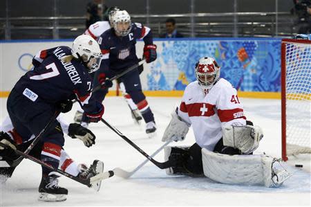 Team USA's Monique Lamoureux (L) scores on Switzerland's goalie Florence Schelling during the first period of their women's preliminary round hockey game at the Sochi 2014 Winter Olympic Games February 10, 2014. REUTERS/Mark Blinch