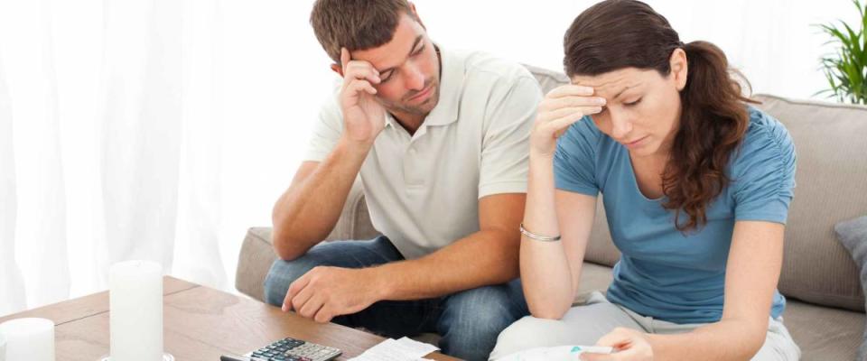 Worried couple doing their accounts in the living room at home