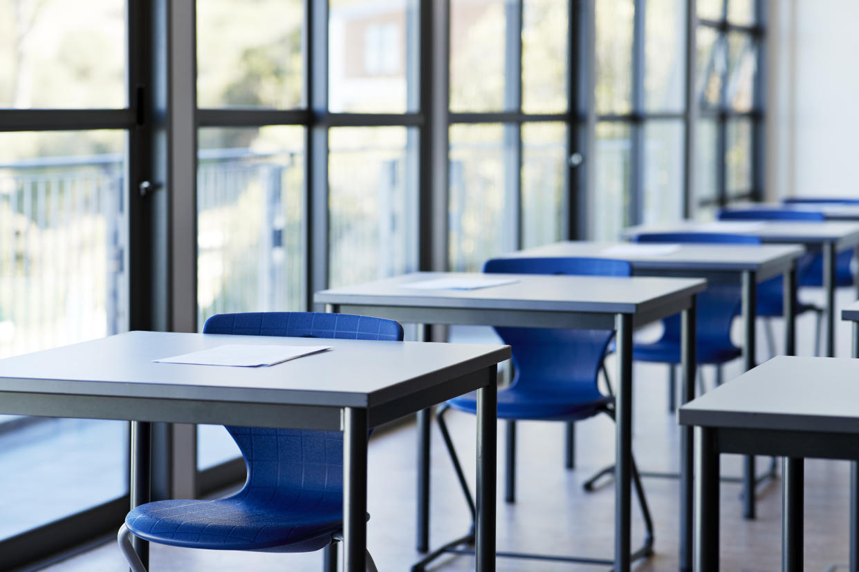 Papers on desks by window in classroom