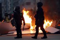 Police officers stand next to a burning barricade during an anti-government protest in Hong Kong China