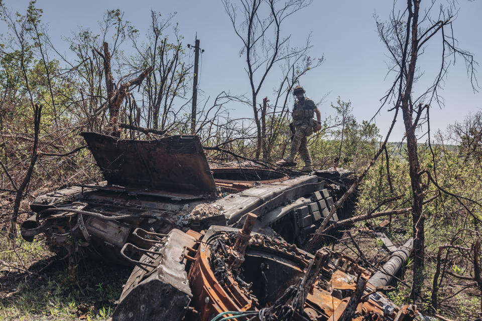 A Ukrainian soldier on a destroyed Russian tank