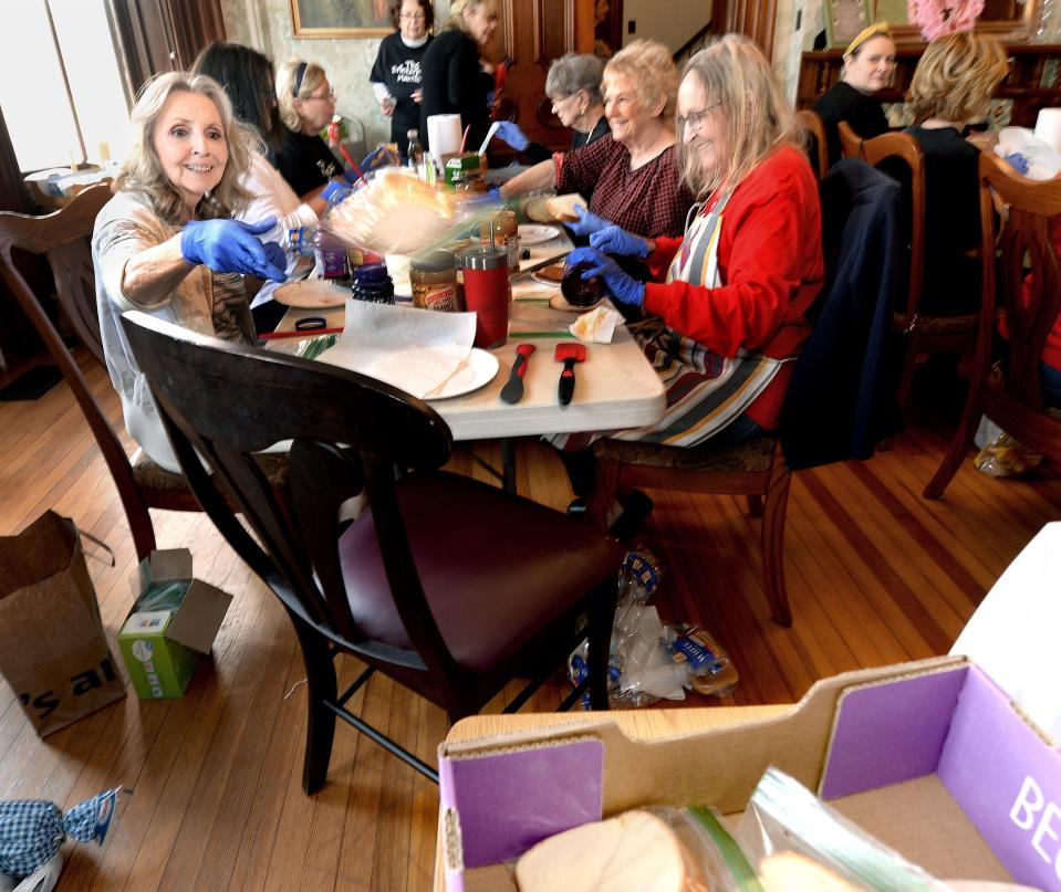 Mary Hinkle of Springfield tosses her finished peanut and jelly sandwiches into a box on Tuesday, Feb.27, 2024, in Springfield. The sandwiches are given out to those in need every week.