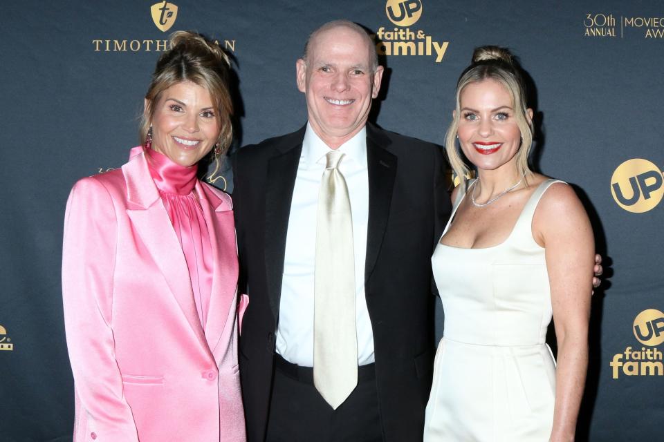 Lori Loughlin in a pink outfit, Candace Cameron Bure in a white dress, and Bill Abbott in a suit pose together at the 30th Annual Movieguide Awards