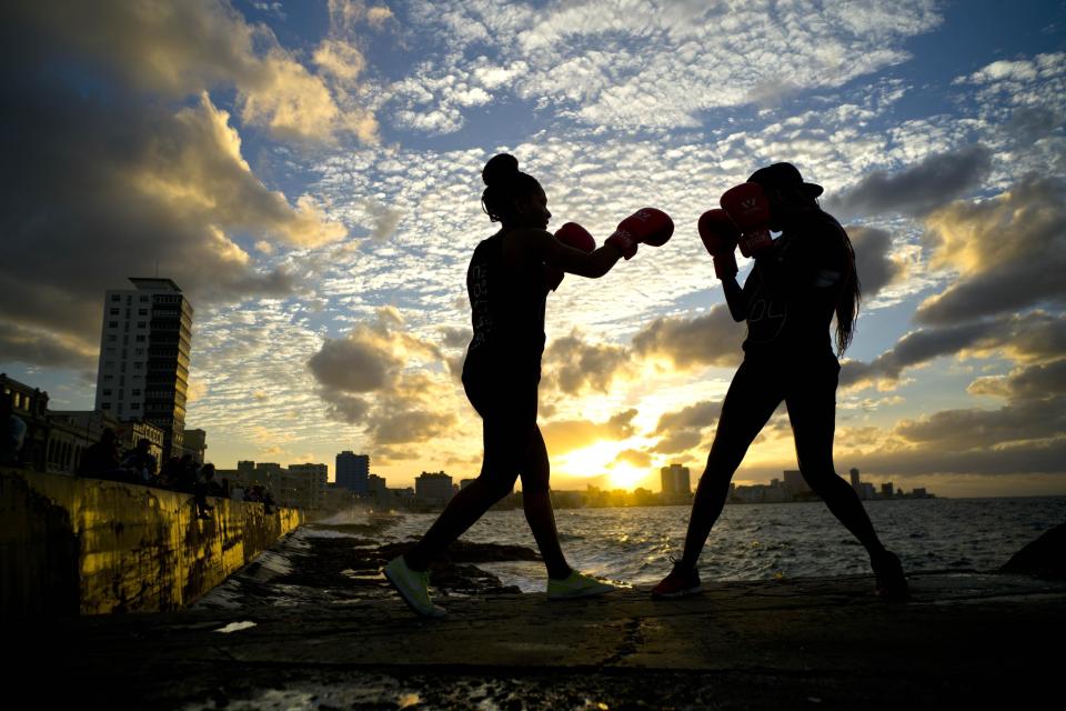In this Jan. 30, 2017 photo, boxers Idamelys Moreno, left, and Legnis Cala, train during a photo session on Havana's sea wall, in Cuba. Moreno and Cala are part of a group of up-and-coming female boxers on the island who want government support to form Cuba's first female boxing team and help dispel a decades-old belief once summed up by a former top coach: "Cuban women are meant to show the beauty of their face, not receive punches." (AP Photo/Ramon Espinosa)