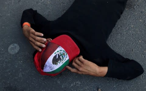 A migrant, part of a caravan traveling from Central America en route to the United States, rests on the street in Mexico City - Credit: REUTERS/Henry Romero