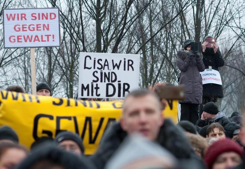 Protesters hold up a sign reading