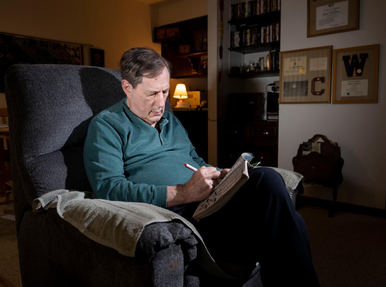 Dylan Abraham fills out his daily crossword puzzle at his condo in Middleton, Wisconsin.
