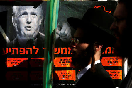 Ultra-Orthodox Jewish man walk next to a poster of Donald Trump in Jerusalem's Mea Shearim neighbourhood, October 13, 2016. REUTERS/Amir Cohen