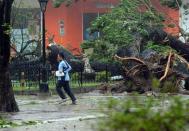 A resident runs past an uprooted tree as Typhoon Haiyan pounds Cebu City, in central Philippines on November 8, 2013