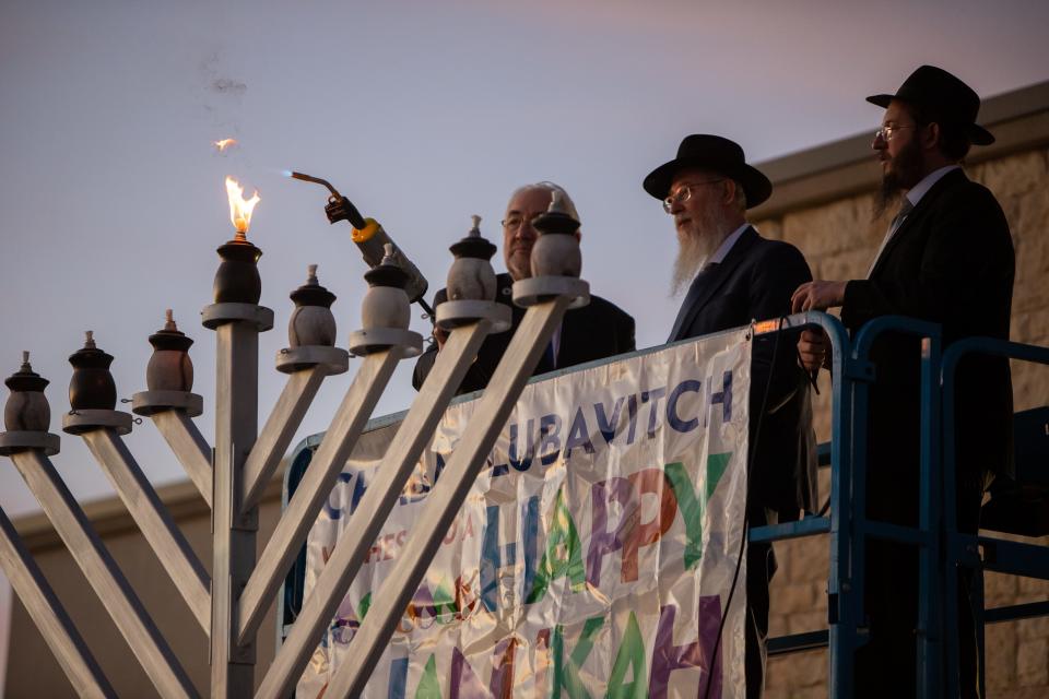 City Representative Brian Kennedy lights the candle of a menorah at Chabad Lubavitch on Thursday, Dec. 7, 2023 celebrating the first day of Hanukkah.