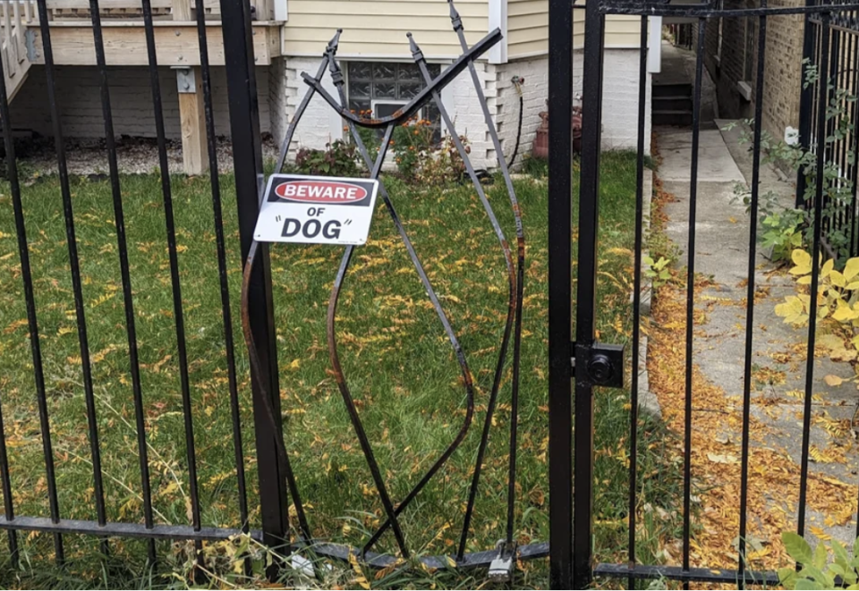 Beware of "dog" sign on a broken fence (with "dog" in quotation marks)