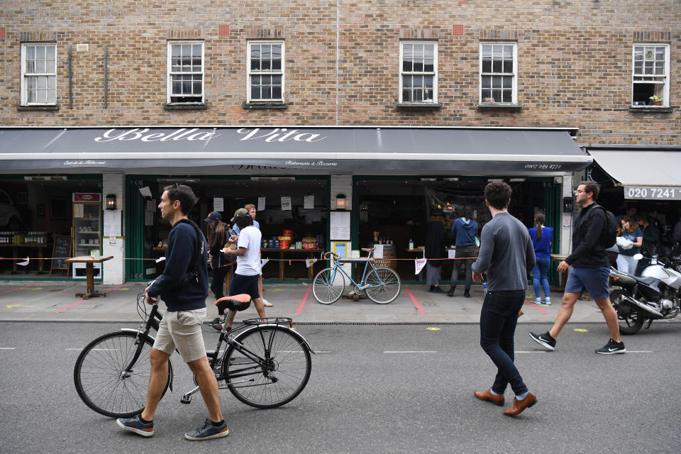 People walk through Broadway Market in London, as the UK continues in lockdown to help curb the spread of the coronavirus.
