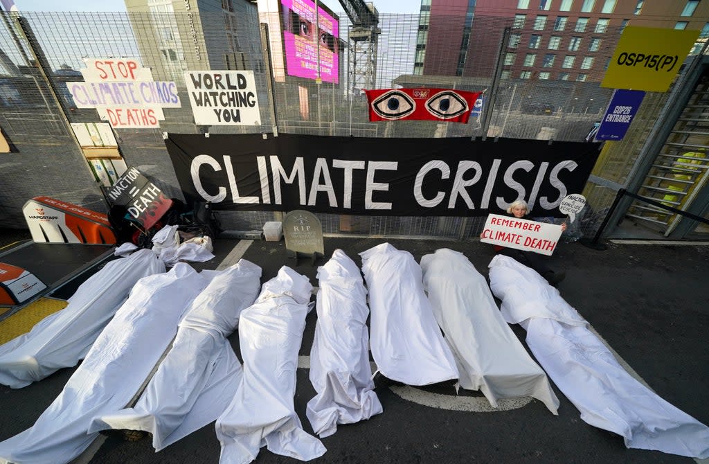 Climate activists dressed as shrouded bodies take part in a protest outside the Cop26 summit (Andrew Milligan/PA) (PA Wire)