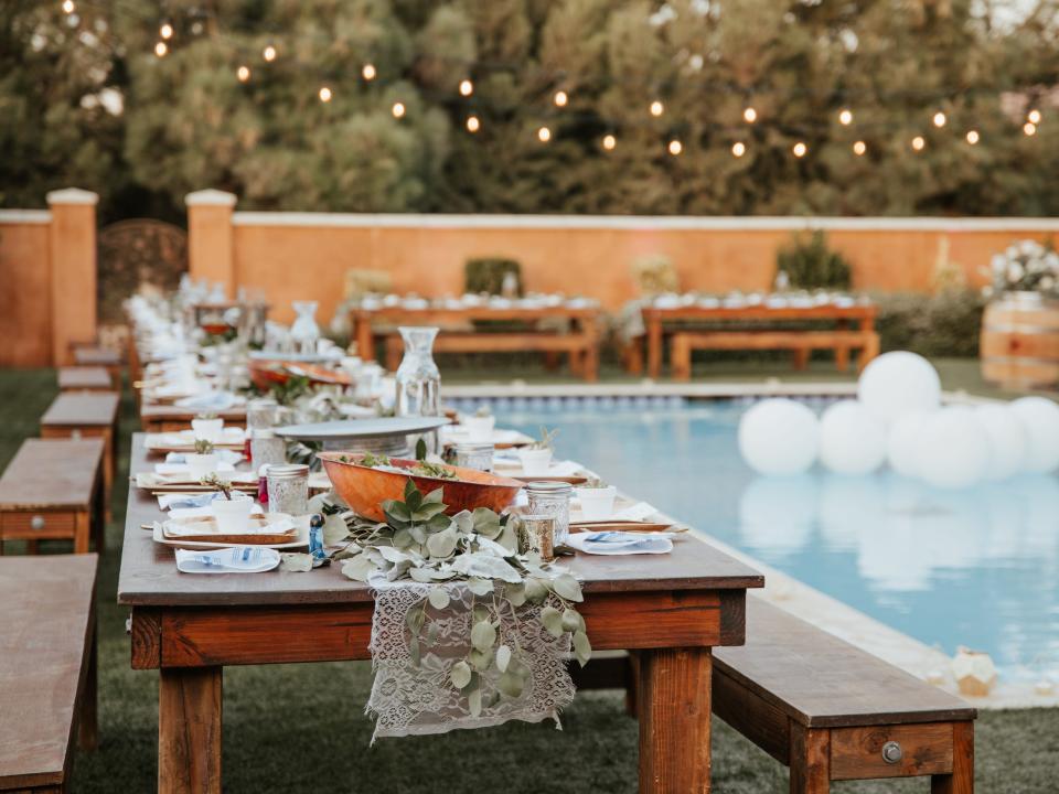 backyard with a pool decorated for a wedding with a set table