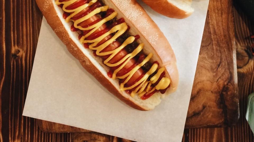 directly above shot of hot dogs on paper at restaurant