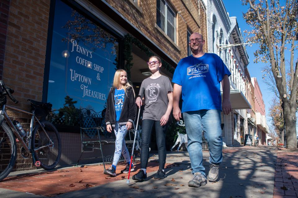 Holton Middle School student Addie Bartels, middle, walks with her  fourth-grade sister Amelia, left, and their father Leslie through downtown Holton last week. Addie has learned to work with her rare visual impairment to make it into the Make48 inventors competition this weekend at the Kansas State School for the Blind.