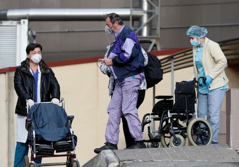 A patient wears an oxygen mask outside a hospital for people infected with the coronavirus disease in Kyiv