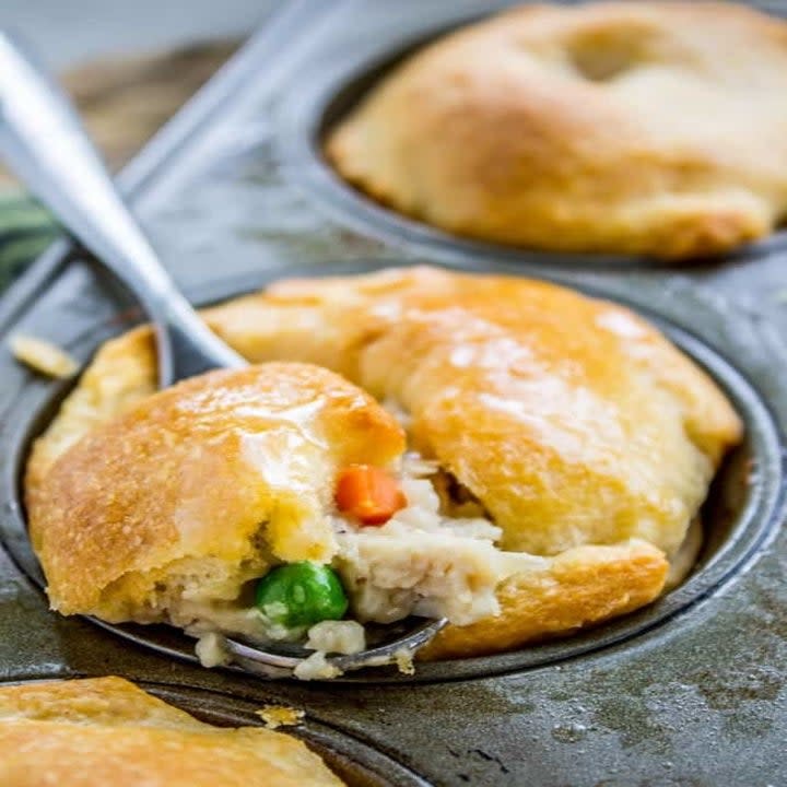 A spoon digging into a mini chicken pot pie