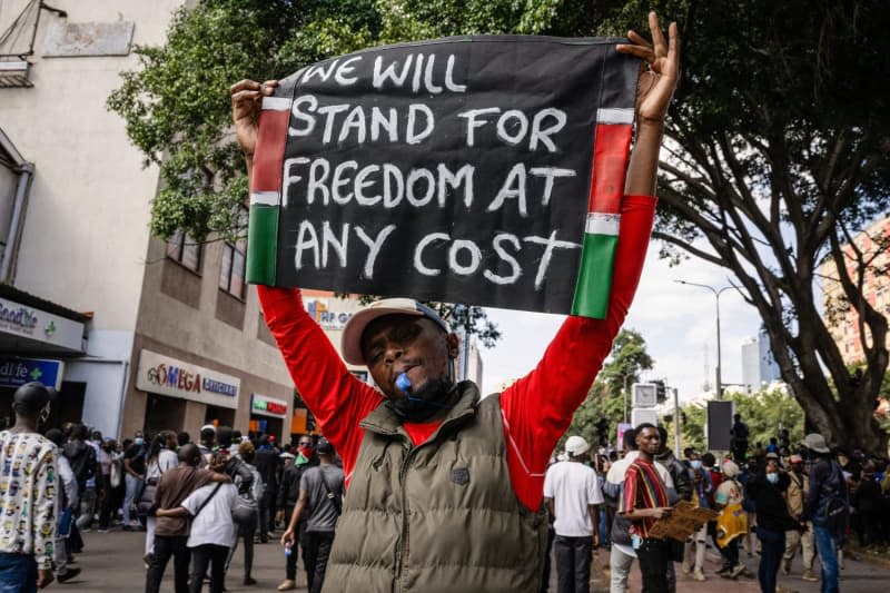 A protester holds a banner during the nationwide demonstrations against proposed taxes in the Finance Bill 2024 in Nakuru Town. Several people were killed and many injured after police opened fire on the protesters. Katie G. Nelson/SOPA Images via ZUMA Press Wire/dpa