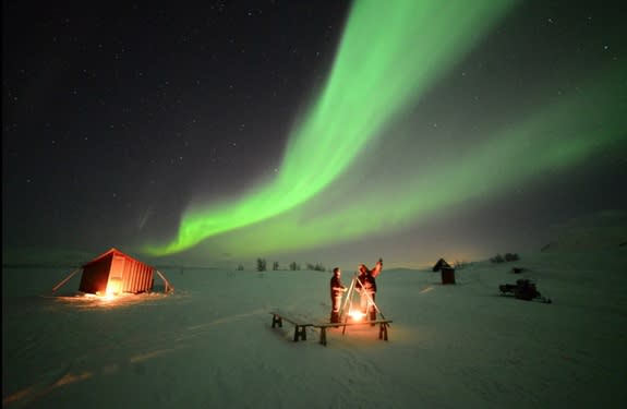 Northern lights glow over skywatchers high in the Swedish mountains on Feb. 21, 2014 in this image from the video “Lights Over Lapland” by Chad Blakley.