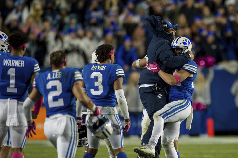 BYU head coach Kalani Sitake jumps into the arms of defensive back Austin Kafentzis, right, during the second half against Boise State in an NCAA football game Saturday, Oct. 19, 2019, in Provo, Utah. (AP Photo/Tyler Tate)