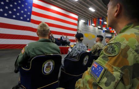 A member of the Australian Army sits in the audience alongside a U.S. flag as the backdrop of a ceremony marking the start of Talisman Saber 2017, a biennial joint military exercise between the United States and Australia, aboard the USS Bonhomme Richard amphibious assault ship on the the Pacific Ocean off the coast of Sydney, Australia, June 29, 2017. REUTERS/Jason Reed