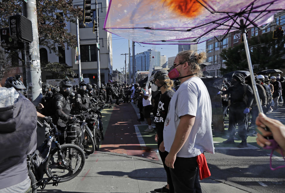 Police square off with protesters Saturday, July 25, 2020, near Seattle Central Community College in Seattle. A large group of protesters were marching Saturday in Seattle in support of Black Lives Matter and against police brutality and racial injustice. (AP Photo/Ted S. Warren)