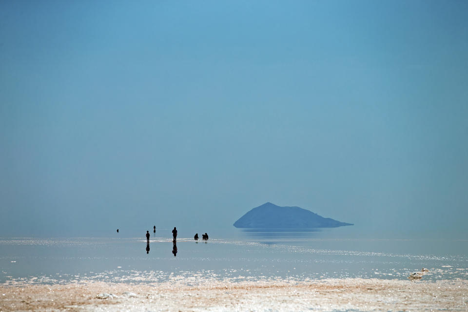 FILE - People spend time in Lake Urmia near Urmia, northwestern Iran on Aug. 26, 2016. A new study Thursday, May 18, 2023, says climate change’s hotter temperatures and society’s diversion of water have been shrinking the world’s lakes, including Lake Urmia, by trillions of gallons of water a year since the early 1990s. (AP Photo/Ebrahim Noroozi, File)