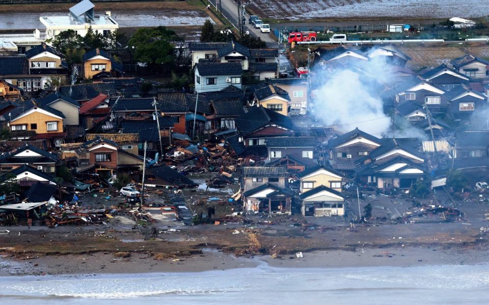 Smoke rises following a tsunami in Suzu