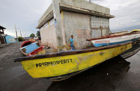 A boy looks on as boats are secured at Port Royal while Hurricane Matthew approaches, in Kingston, Jamaica October 2, 2016. REUTERS/Henry Romero