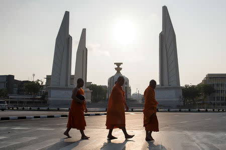 Buddhist monks walk past the Democracy Monument ahead of voting, during the general election in Bangkok, Thailand March 24, 2019. REUTERS/Cory Wright