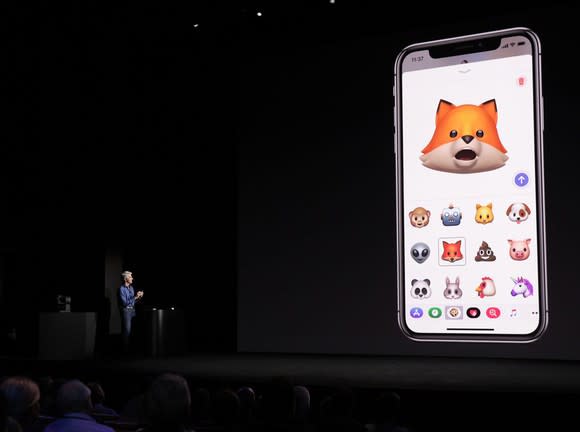 An Apple executive demonstrating the iPhone X on stage.