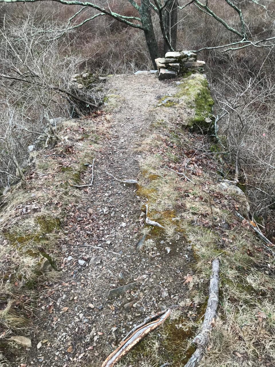An earthen and stone bridge is all that remains from the site of a stone-crushing machine used to quarry granite.